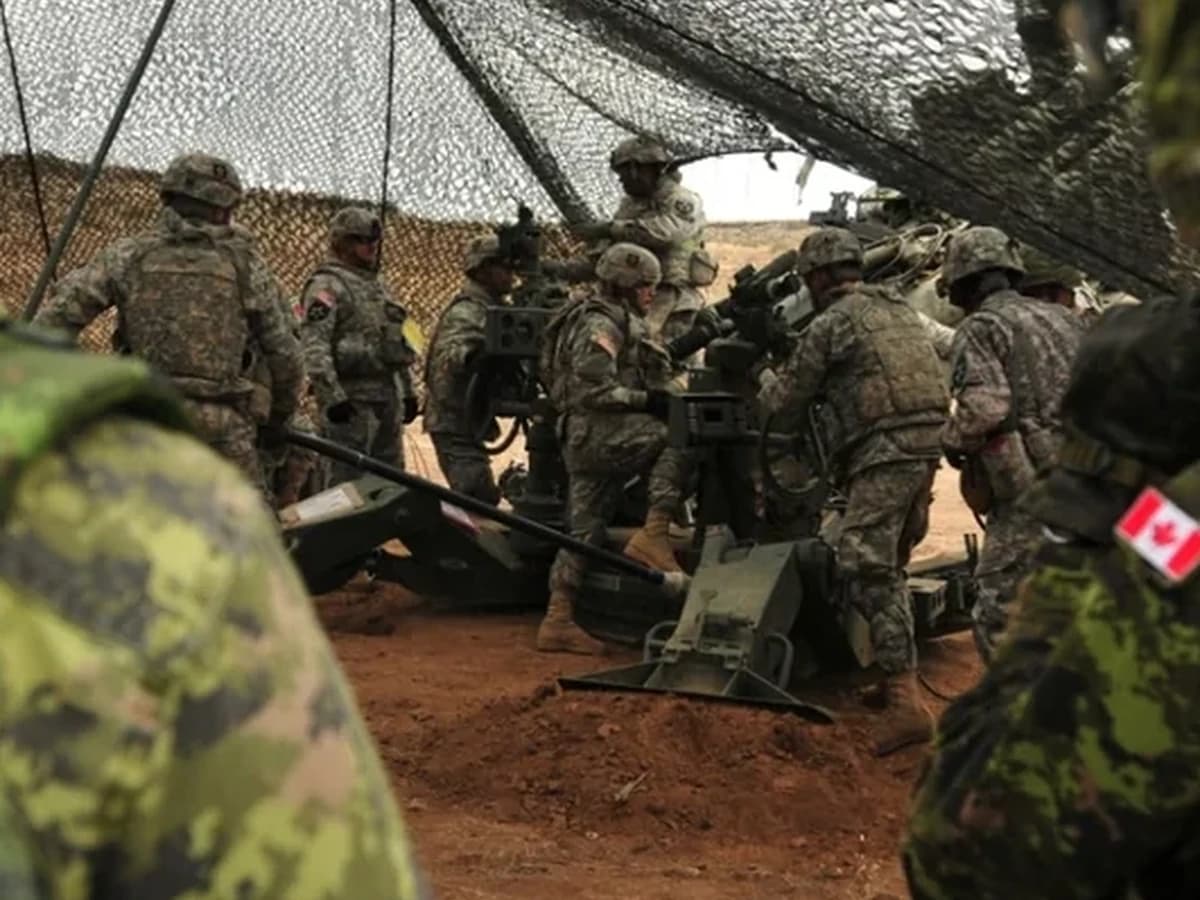 Canadian and United States military personnel working together in the field