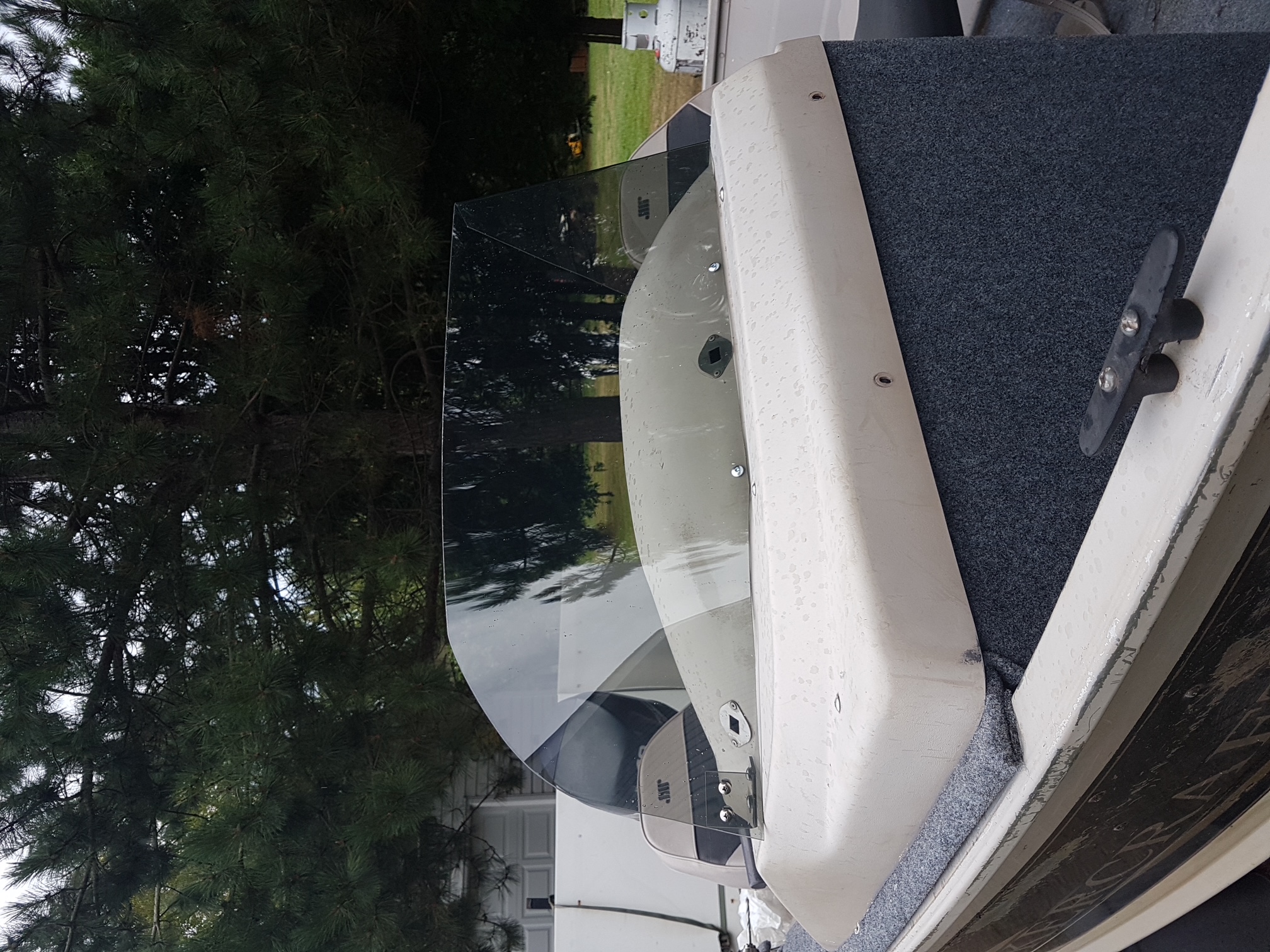 Low-profile smoked windshield mounted on a white boat console