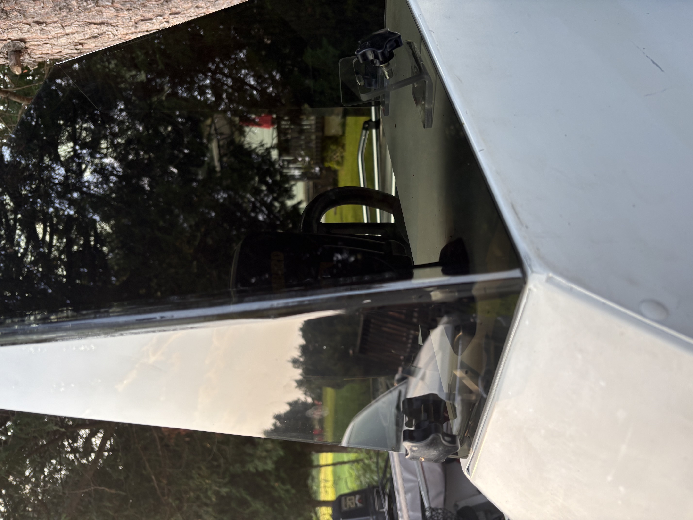 Close-up of a smoked boat windshield fitted against the boat console